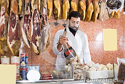 Smiling male seller showing jamon Stock Photo